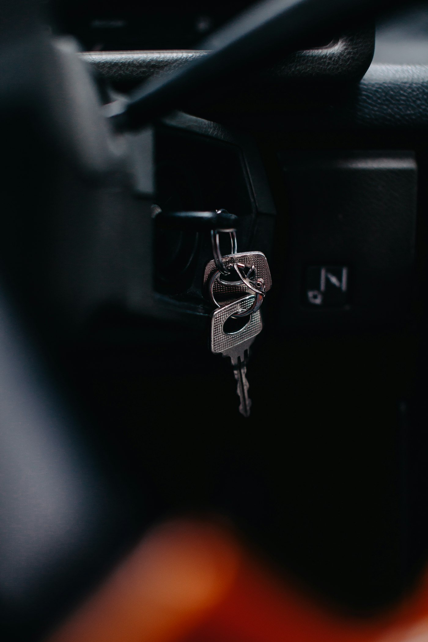 Clé insérée dans le contact d'une voiture, dans la pénombre